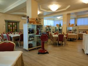 - un restaurant avec des tables, des chaises et un ventilateur rouge dans l'établissement Da Gianni Hotel, à Zogno