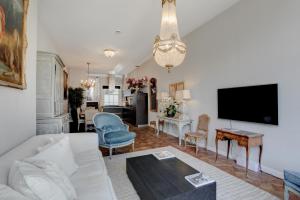a living room with a white couch and a tv at Keizersgracht Residence in Amsterdam
