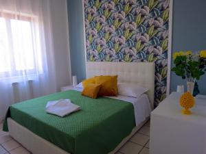 Dormitorio pequeño con cama con manta verde en Syrene Apartment, en Sorrento