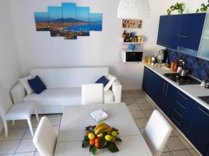 cocina y sala de estar con una mesa con fruta. en Syrene Apartment, en Sorrento
