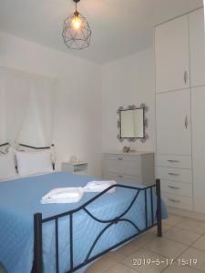 una camera con letto blu e specchio di Katerina & Joanna Adamas Studio Milos ad Adámas