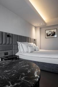 a bedroom with a large white bed and a table at Hotel VEGA Sofia in Sofia