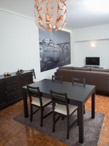 OPORTO GUEST Cedofeita Terrace في بورتو: غرفة معيشة مع طاولة وكراسي وأريكة