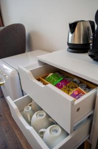 ミュンヘンにあるHOMELY STAY Studio 8 - Relaxed Self-Check-In room in Munich - 15 min from Oktoberfestの白いキャビネットの引き出し(食器、ティーポット付)