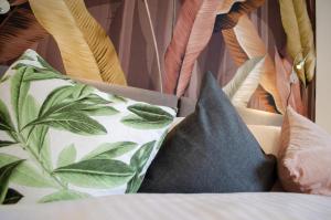 ein Haufen Kissen auf einem Bett mit Vorhang in der Unterkunft HOMELY STAY Studio 8 in München