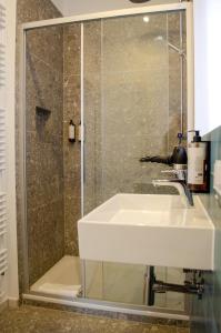 ミュンヘンにあるHOMELY STAY Studio 8 - Relaxed Self-Check-In room in Munich - 15 min from Oktoberfestの白い洗面台とシャワー付きのバスルーム