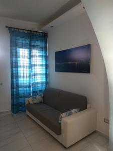a living room with a couch in front of a window at Casa in borgo marinaro in Giardini Naxos
