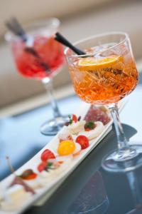 - un plateau avec deux cocktails et une assiette de nourriture dans l'établissement Villa Sylva & Spa, à Sanremo
