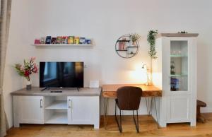 a desk with a television and a desk with a chair at L&G's Apartment - Balcony - Close to Car Park in Vienna