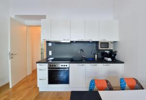 a kitchen with white cabinets and a stove at L&G's Apartment - Balcony - Close to Car Park in Vienna