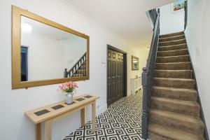 a hallway with a staircase with a mirror and a table at Contractors, Larger Groups, sleeps 14, Iver House, Buckinghamshire, in Buckinghamshire