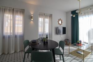 a dining room with a table and green chairs at Apartamentos Teatro by Be Alicante in Alicante