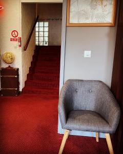 a chair sitting in a room with a staircase at Hotel Italia in Tours