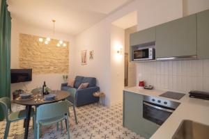 una cucina e un soggiorno con tavolo, cucina e soggiorno di Apartamentos Teatro by Be Alicante ad Alicante