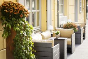 uma fila de sofás numa varanda com flores em Boutique Hotel Das Tigra em Viena