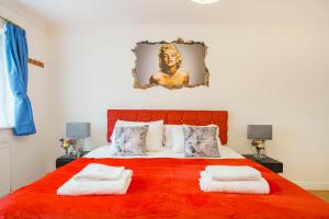 a bedroom with a large bed with two towels on it at Contractors, Larger Groups, sleeps 14, Iver House, Buckinghamshire, in Buckinghamshire