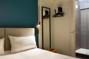 a bedroom with a white bed and a shower at Ibis Marseille Centre Prefecture in Marseille