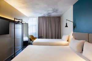 um quarto de hotel com duas camas e uma televisão em Ibis Marseille Centre Prefecture em Marselha