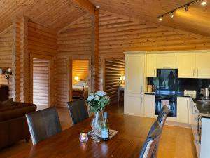 a kitchen and dining room with a table in a cabin at Strathisla - Luxury Two Bedroom Log Cabin with Private Hot Tub & Sauna in Berwick-Upon-Tweed