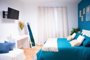 una camera da letto blu e bianca con un letto e un divano di Quisì - Salerno Centro a Salerno