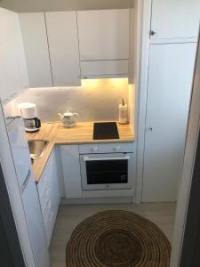 uma pequena cozinha com armários brancos e um fogão em Studio in the center with free private parking em Kemi