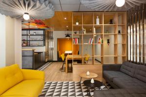 a living room with a yellow couch and a table at Ibis Marseille Centre Prefecture in Marseille +44 photos