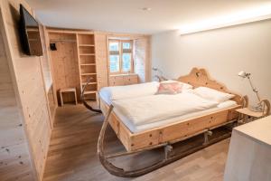 a bedroom with a bed and a tv in it at Hotel Wasserfall in Jaun