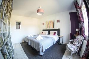 a bedroom with a bed and a chair at La Girouardière in La Flèche