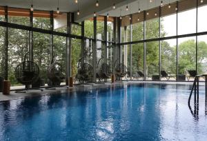 einen großen Pool mit Stühlen und Fenstern in der Unterkunft Konsum Gästehaus Quisisana - Nebenhaus Berghotel Oberhof - nur Übernachtung in Oberhof