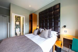 a bedroom with a large bed with a large headboard at Escape Boutique B&B in Llandudno