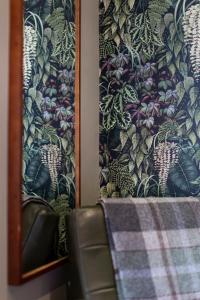 a table with a curtain and a chair next to a mirror at Escape Boutique B&B in Llandudno
