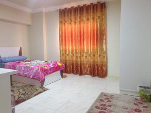 una camera con letto e tenda in una stanza di سكن للذكور فقط - Sakan Male Only a Città del 6 ottobre