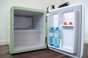 an open refrigerator with two bottles of water in it at HOMELY STAY Studio 9 - Stylish & Convenient Self-Check-In Studio in Munich in Munich