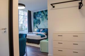 ein Schlafzimmer mit einem Bett und einer Kommode sowie ein Schlafzimmer in der Unterkunft HOMELY STAY Studio 9 in München