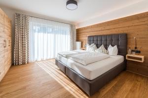 a bedroom with a large bed and a large window at Oberstdorfer Ferienwelt in Oberstdorf