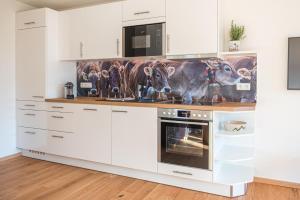 a kitchen with a painting of cows on the wall at Oberstdorfer Ferienwelt in Oberstdorf