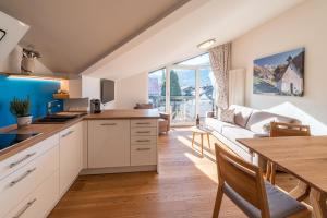 a kitchen and living room with a couch and a table at Oberstdorfer Ferienwelt in Oberstdorf