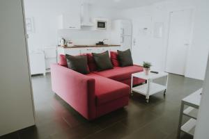 a red couch in a living room with a table at Apartamentos ZHR 2 in Zahara de los Atunes