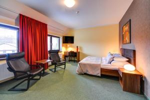 um quarto de hotel com uma cama, uma secretária e cadeiras em Hotel Hermes em Krnov