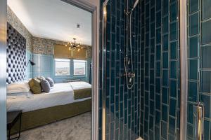 a bedroom with blue walls and a bed with a window at Escape Boutique B&B in Llandudno