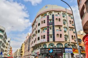a pink building with a dome on top of it at Rahab Hotel in Dubai