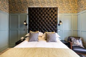 a bedroom with a large bed with a black headboard at Escape Boutique B&B in Llandudno