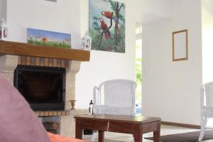 sala de estar con chimenea y mesa en Rénovation proche lac et mer, en Landevieille