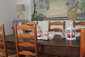 mesa de comedor con sillas y mesa de madera con platos en Rénovation proche lac et mer, en Landevieille