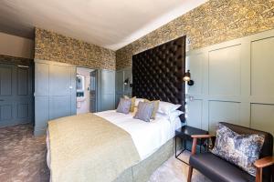 a bedroom with a large bed and a chair at Escape Boutique B&B in Llandudno