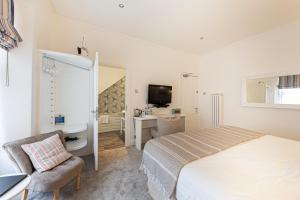 a bedroom with a bed and a bathroom with a sink at Escape Boutique B&B in Llandudno