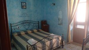 a bedroom with a bed and a surfboard on the wall at Casa Vacanze Central Cincotta in Lipari