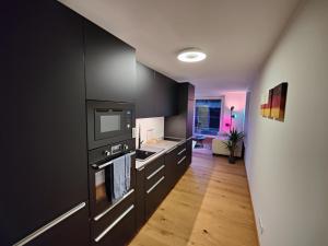 cocina con armarios negros y microondas en Penthouse Flat Carolina in Salzburg Stadt, en Salzburgo