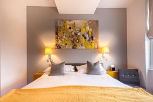 a bedroom with a bed with a painting on the wall at Escape Boutique B&B in Llandudno