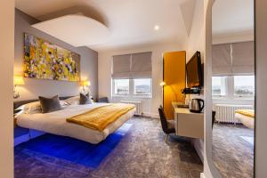 a hotel room with a large bed and a desk at Escape Boutique B&B in Llandudno